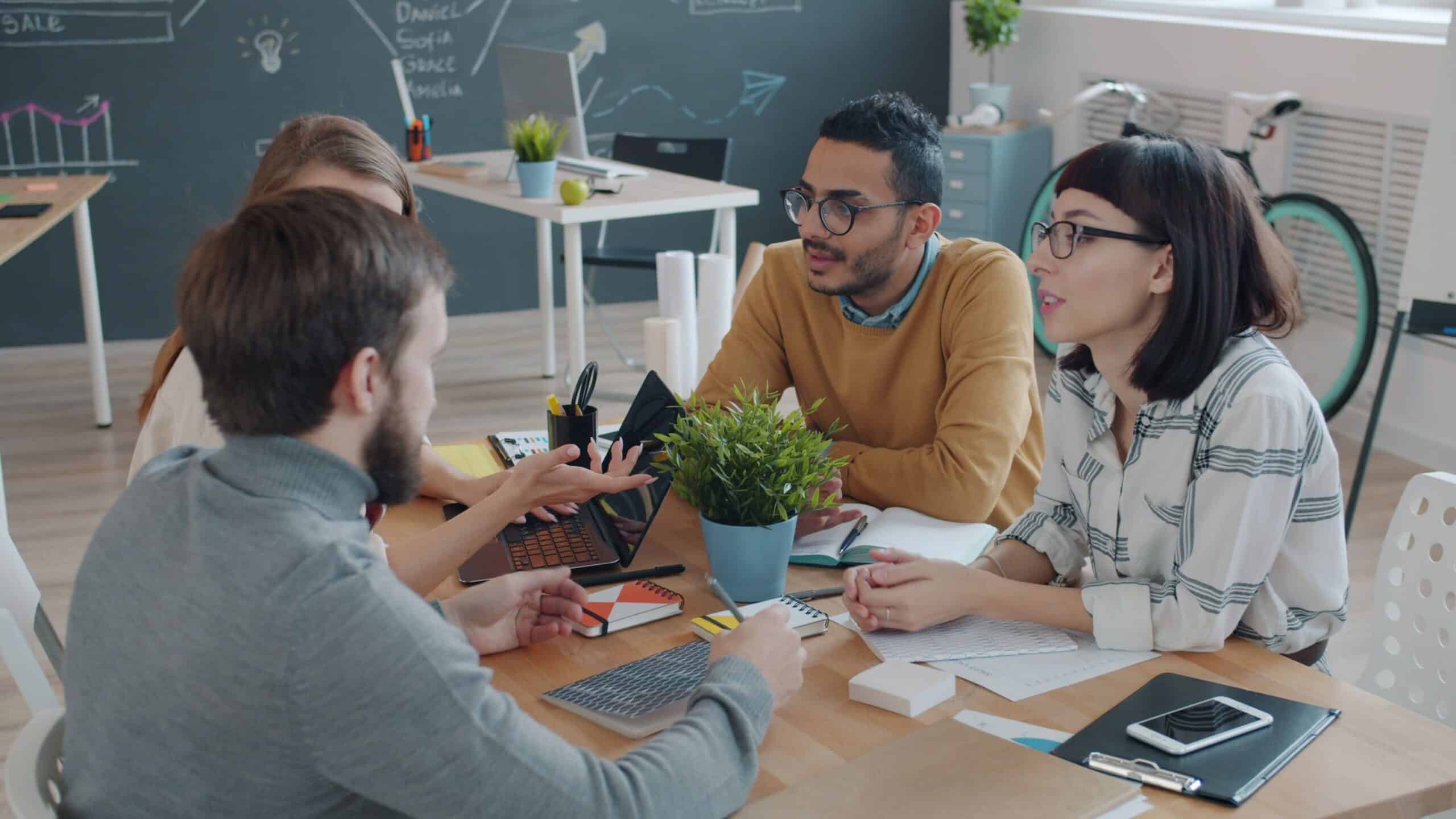 Team im Gespräch am Konferenztisch – offener Austausch statt Konfliktvermeidung im Arbeitsalltag